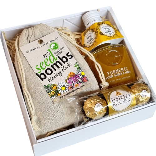 White gift box with wildflower healing herb seed bombs, tumeric lemon honey syrup and ferrero rocher