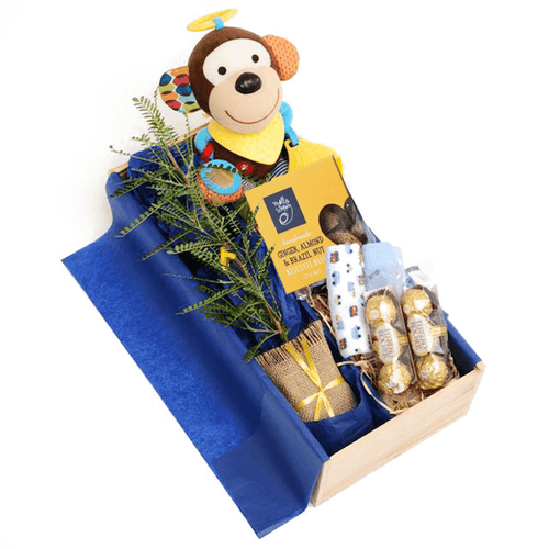 Wooden gift hamper including tree gift, monkey activity stroller toy, biscotti, baby wash cloths and Ferrero chocolates